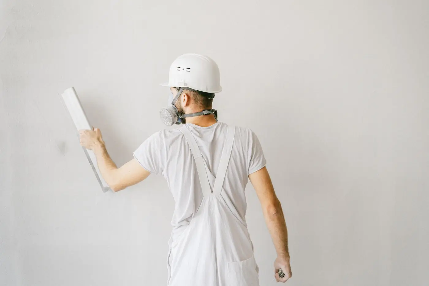 Aplicador trabajando con llana sobre una pared para una terminación de estuco