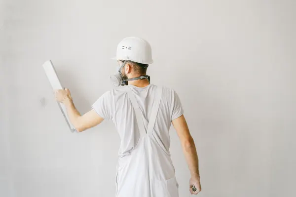 Aplicador trabajando con llana sobre una pared para una terminación de estuco
