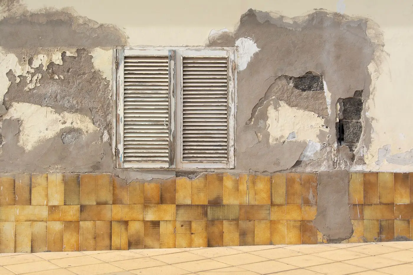 Pared con la pintura y el revoque caídos por humedad de cimientos