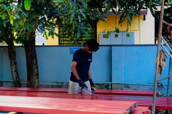 Pintor pintando con pincel unas rejas de hierro