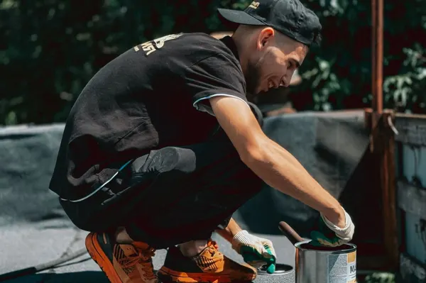 Trabajador aplicando producto impermeabilizante sobre una terraza